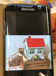 Picture of a toy house on a phone screen